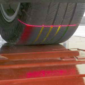 A close up shot of the Hunter Quick Tread Edge being used, a laser is shining onto a car tyre.